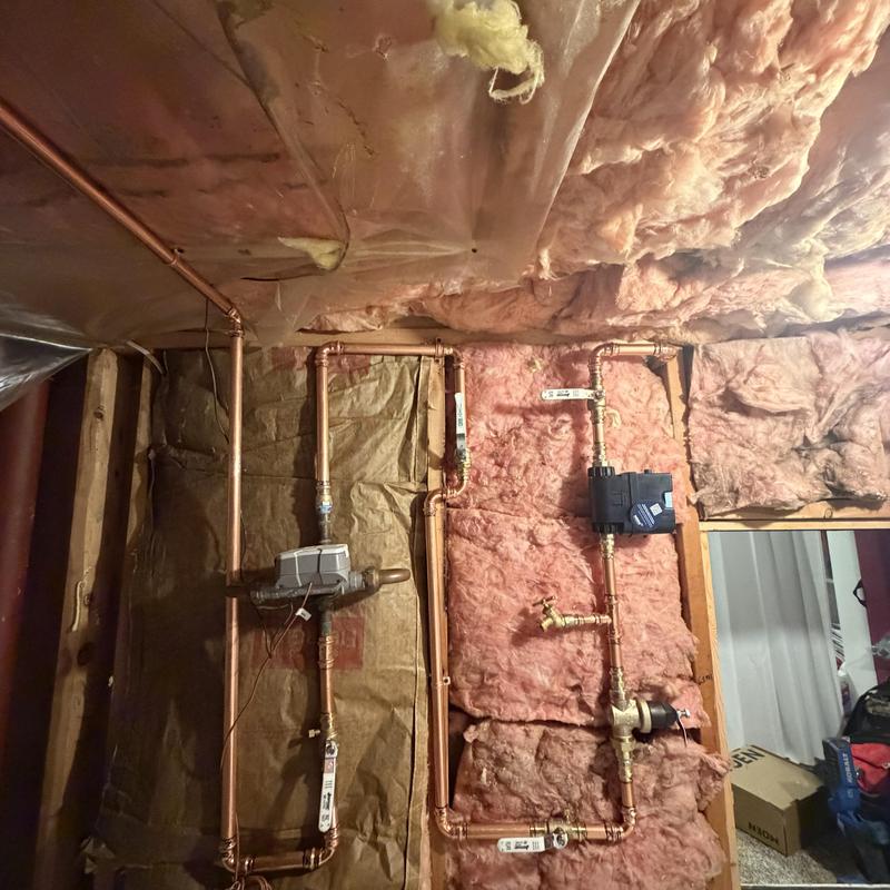 Copper water piping installation with meter in insulated wall
