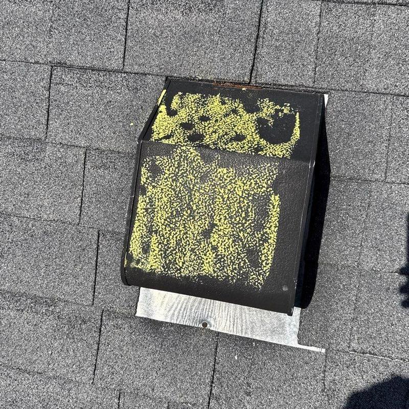 Roof vent with hail damage marked in yellow on shingles