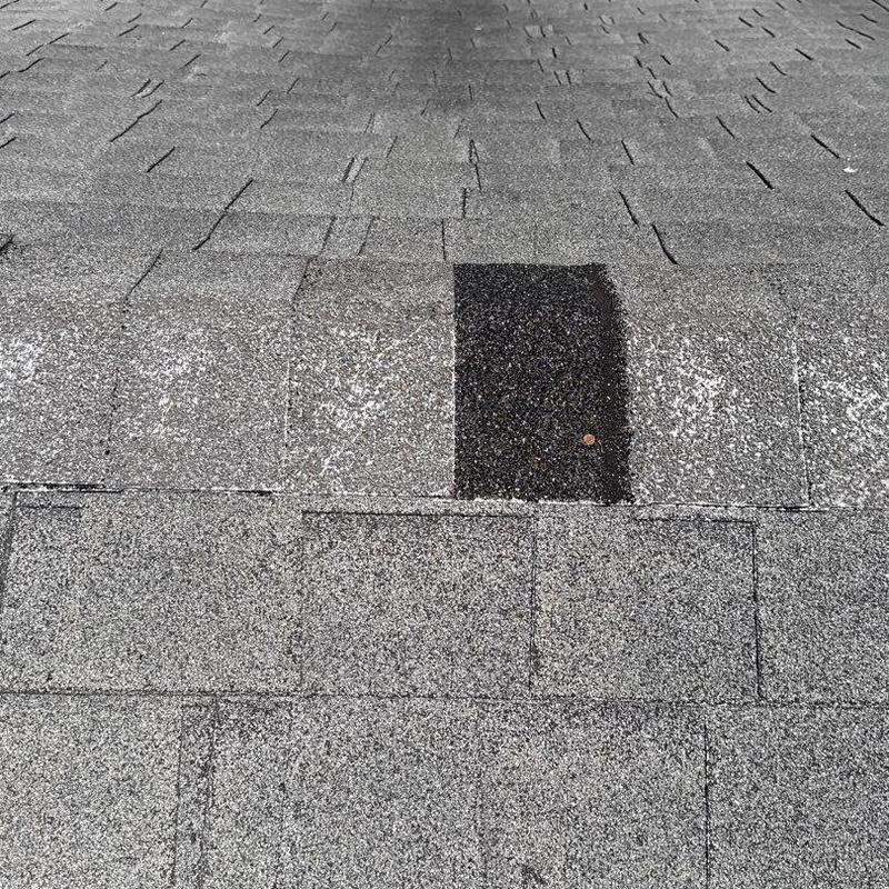 Asphalt shingles with hail damage patch on roof
