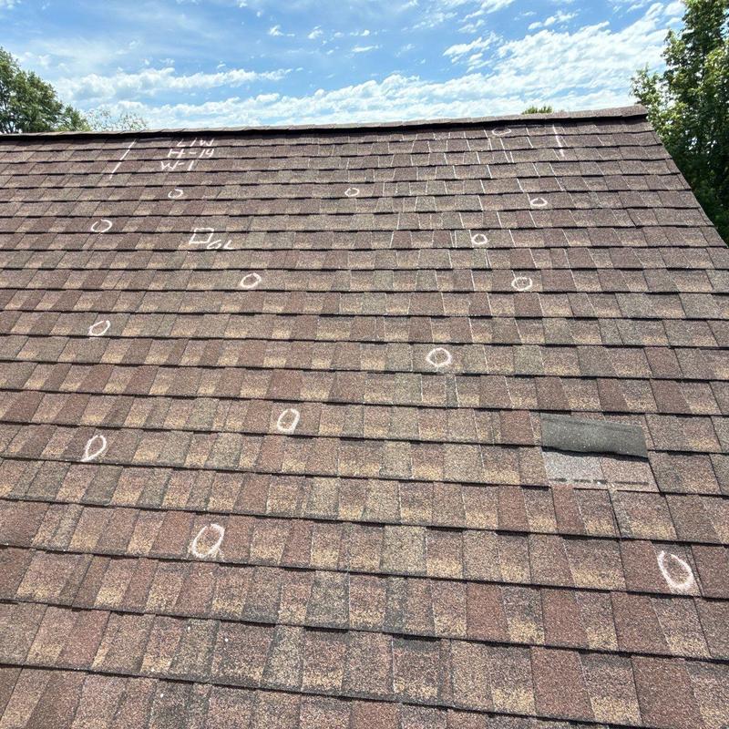 Asphalt shingles with hail damage markings on roof