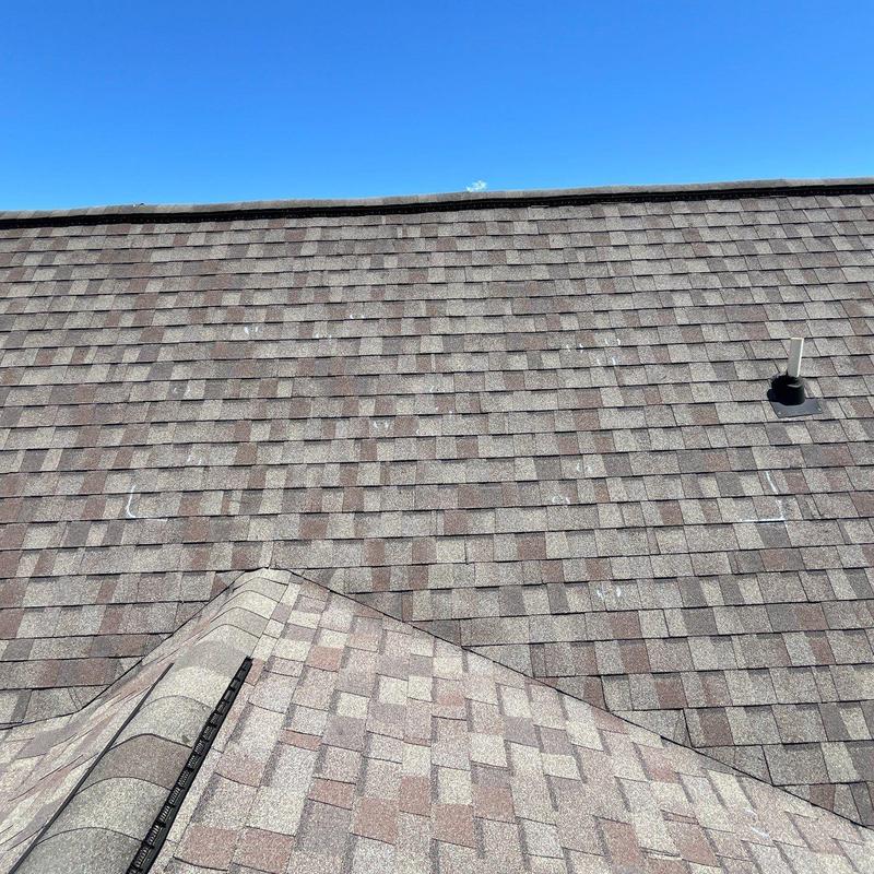 Asphalt shingle roof with hail damage and ventilation pipe
