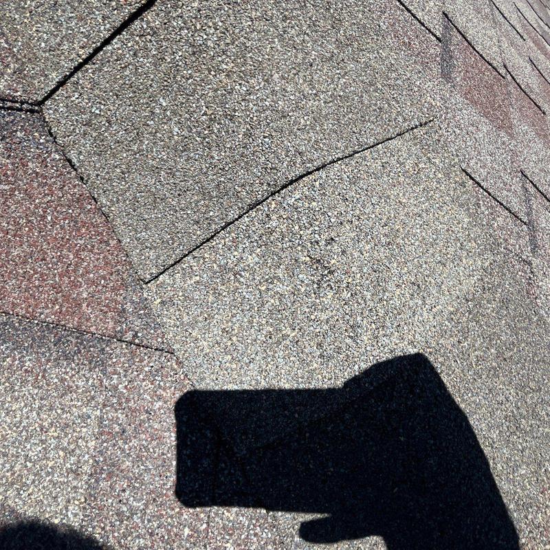 Roof shingle granules with hail damage close-up view