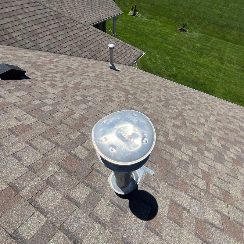 Roof vent cap with hail damage on asphalt shingles