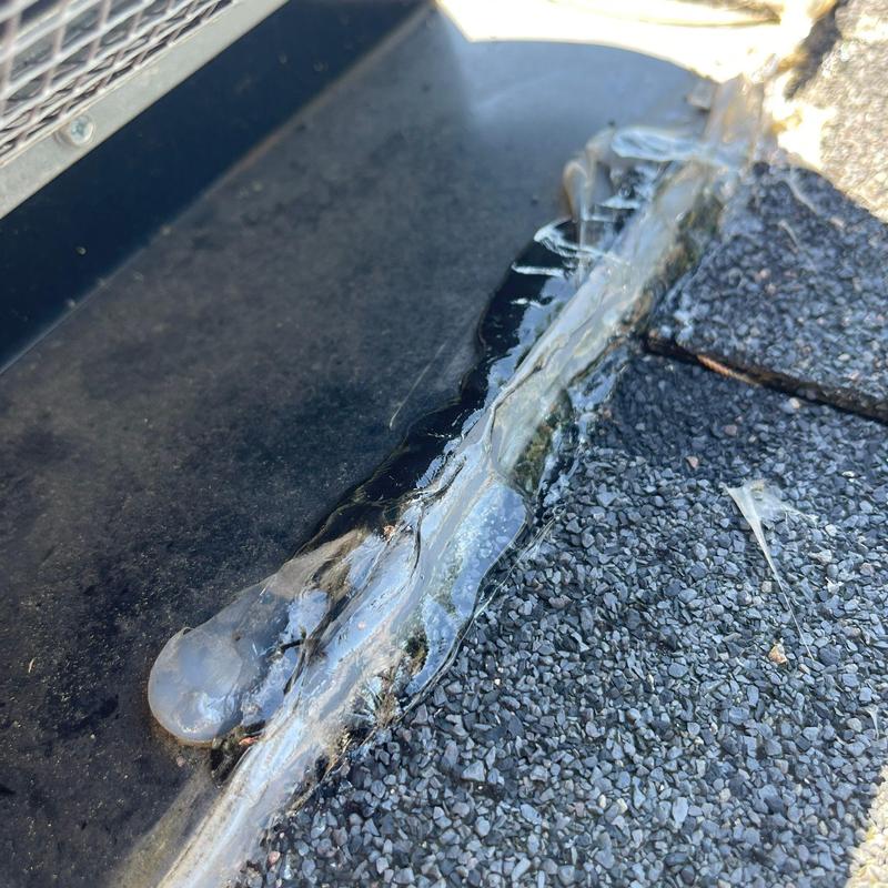 Roof valley with sealant and asphalt shingles close-up