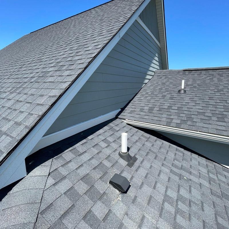 Asphalt shingle roof with vent pipes and ridge caps