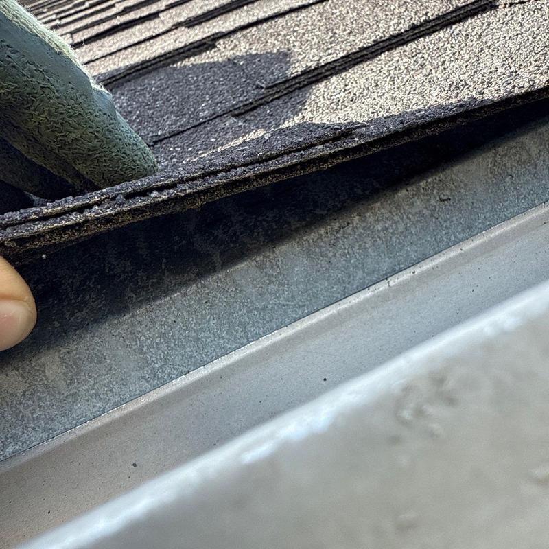 Shingle roof layers lifted to inspect hail damage