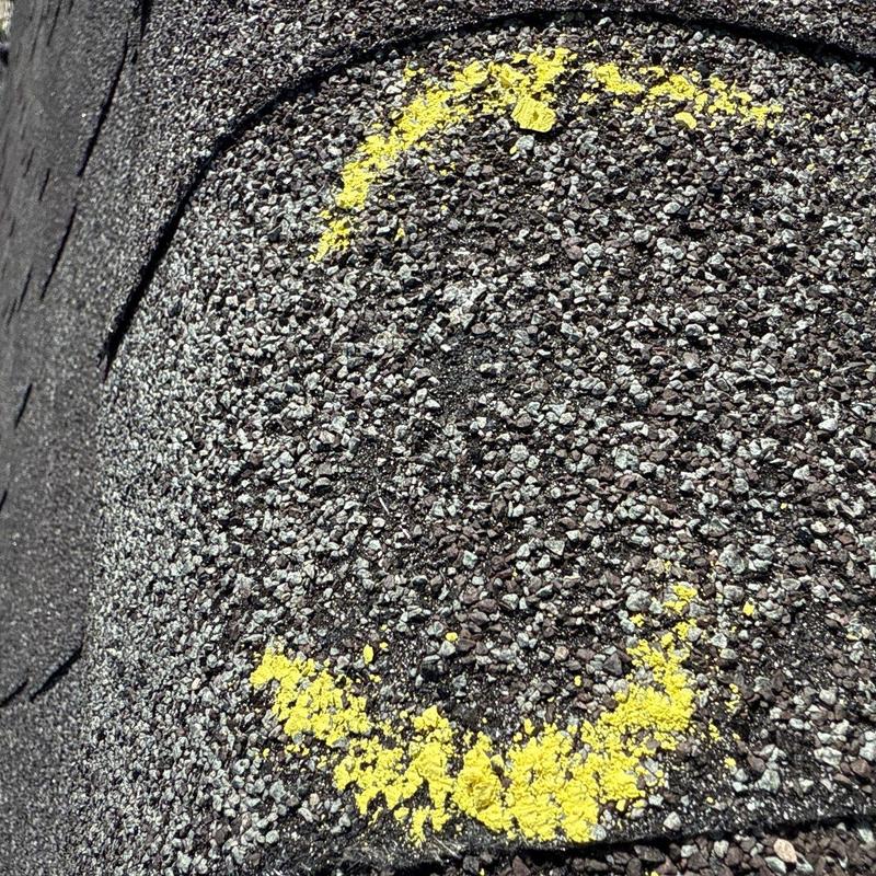 Roof shingle hail damage marked with yellow spray paint
