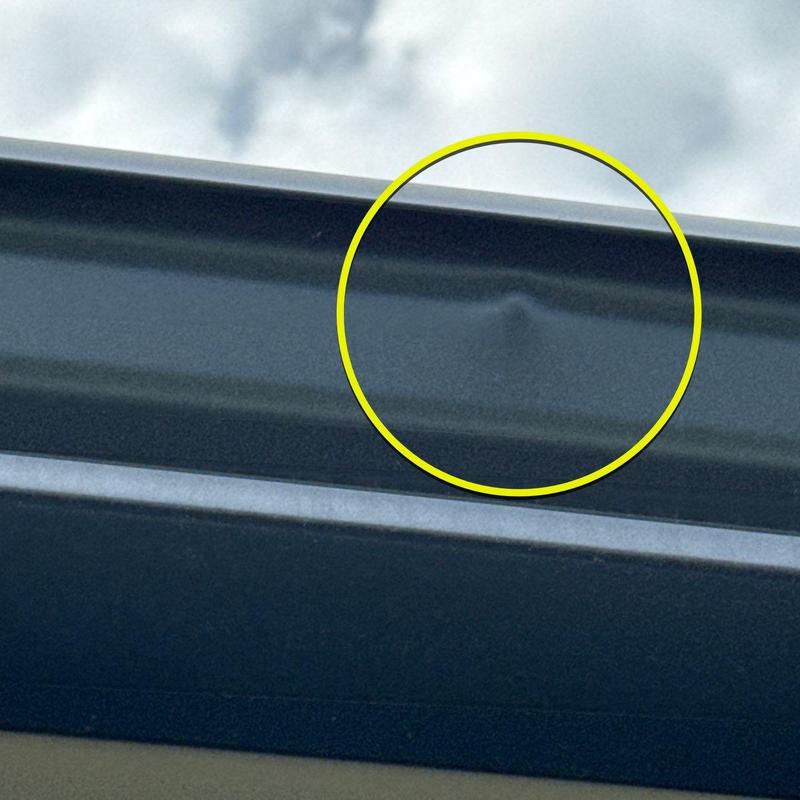 Metal roof flashing with hail dent damage in yellow circle