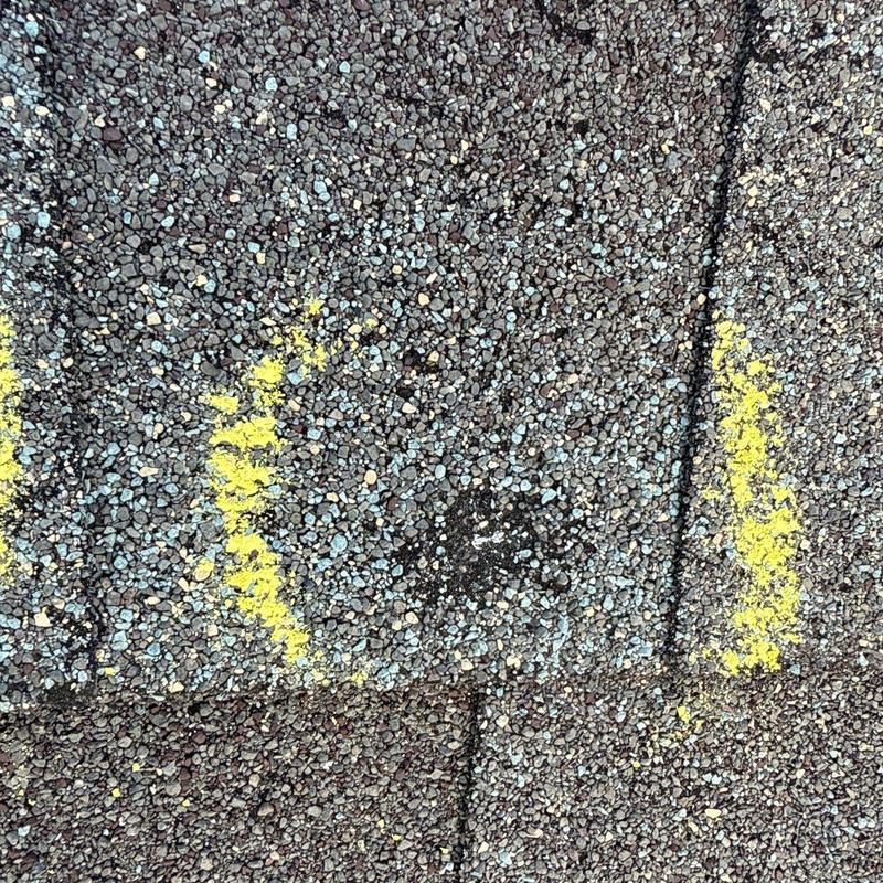 Asphalt shingle hail damage marked with yellow chalk