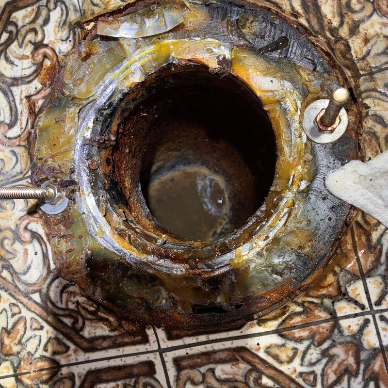 Toilet flange and old wax ring with rust and corrosion