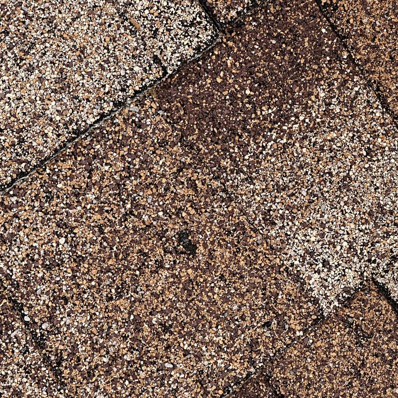 Asphalt shingles with hail and water damage close-up