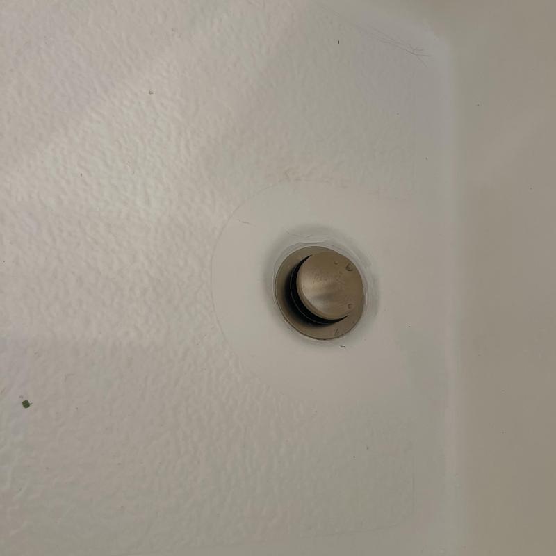 Champagne bronze tub drain in white bathtub