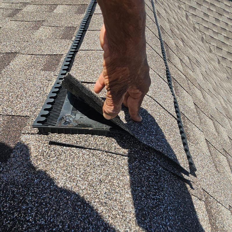Shingle roofing vent with lifted cover during inspection