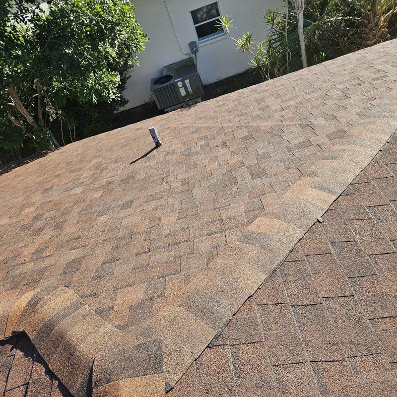 Shingle roof with replaced shingles and ridge cap detail
