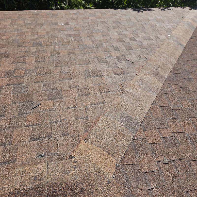 Asphalt shingle roof with replaced damaged shingles