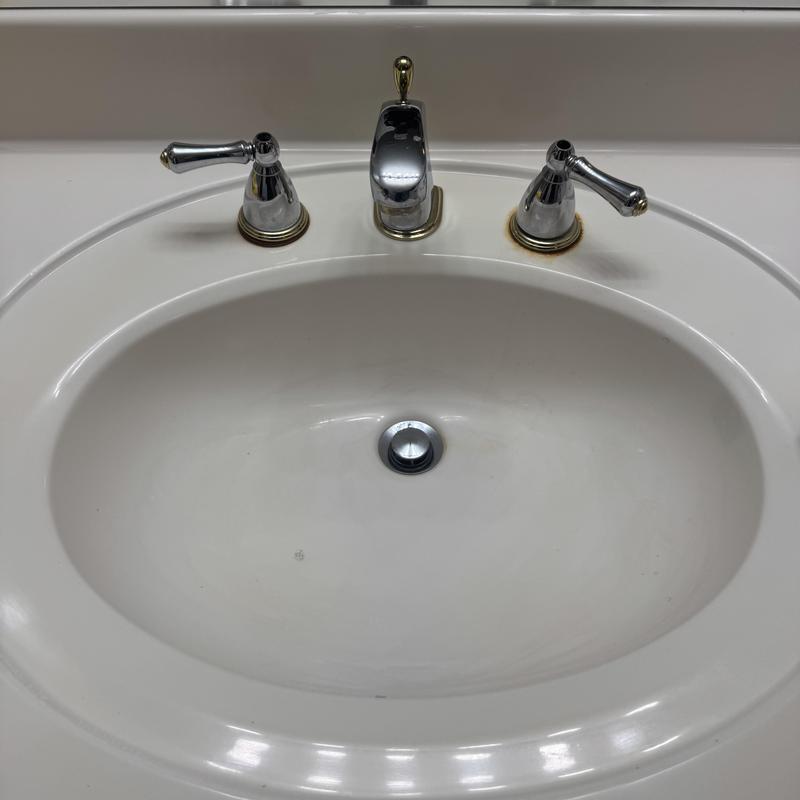 Delta bathroom faucet and sink in white countertop