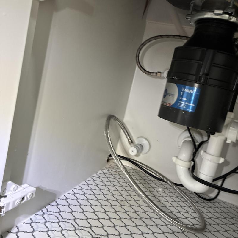 Garbage disposal and plumbing connections under sink