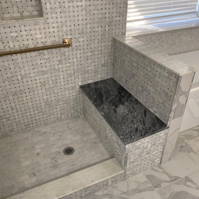 Frameless shower enclosure with tile bench seat