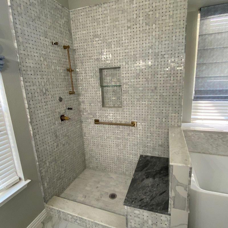 Frameless tiled shower with bench and gold fixtures