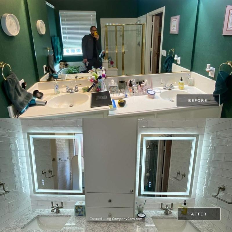 Double vanity with lighted mirrors and tile backsplash