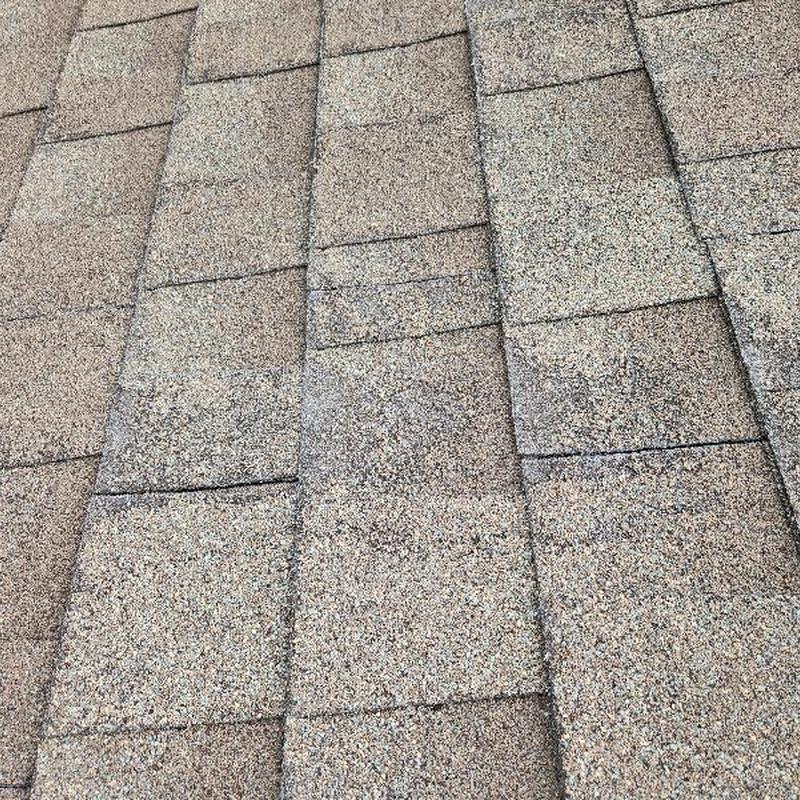 Asphalt roof shingles with granule loss and hail damage Asphalt roof shingles with granule loss and hail damage
