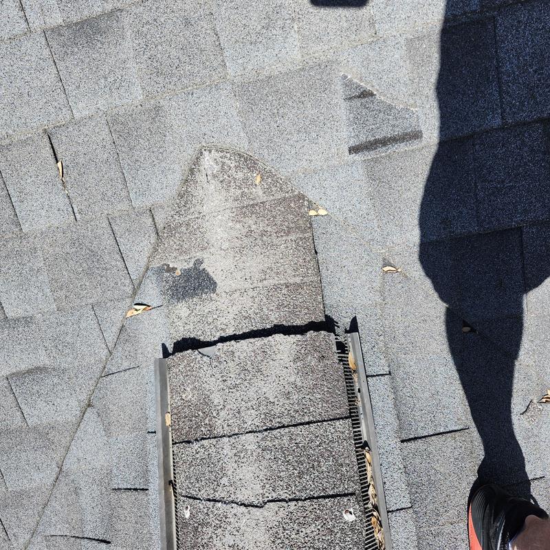 Ridge shingles with cracks and granular loss on roof