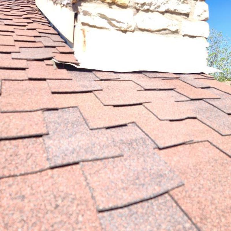 Roof shingles and chimney flashing with hail damage