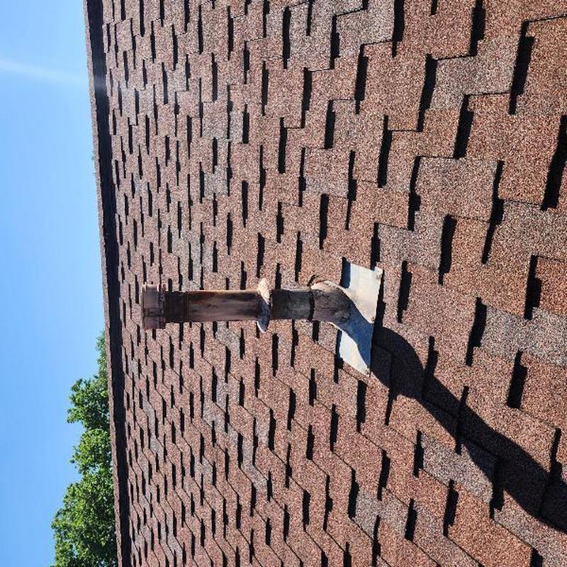 Roof vent flashing and shingles on brown roof
