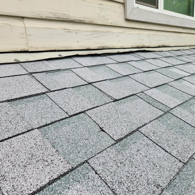 Roof shingles with exposed nails and loose flashing