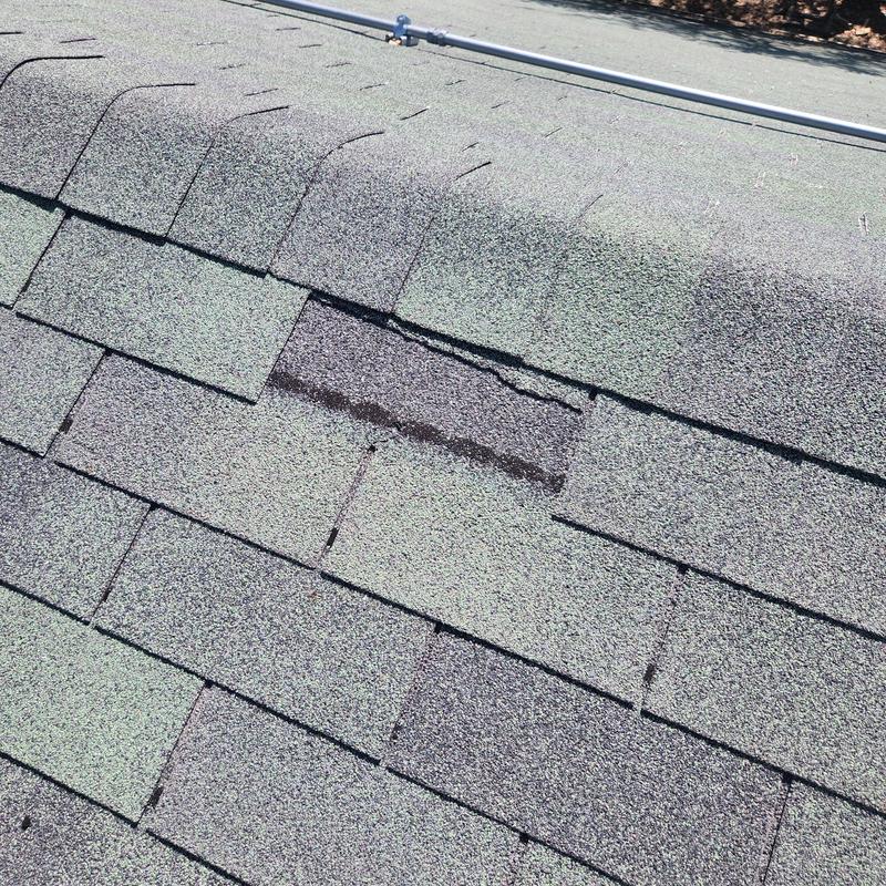 Asphalt roof shingles with minor damage and wear
