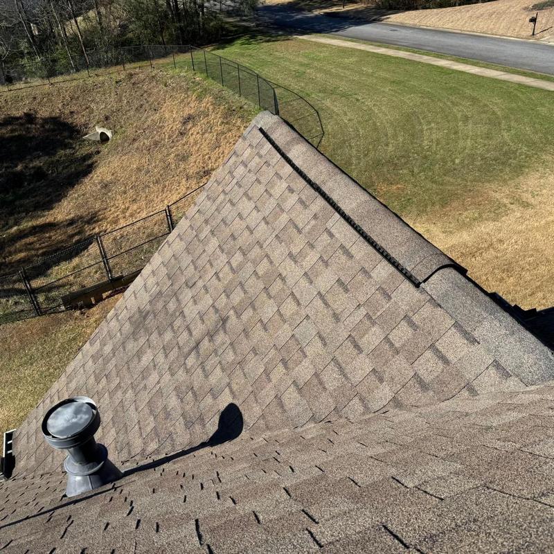 Asphalt shingle roof with loose shingles on ridge line