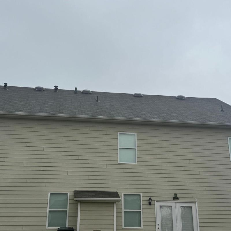 Asphalt roof with storm-damaged loose shingles
