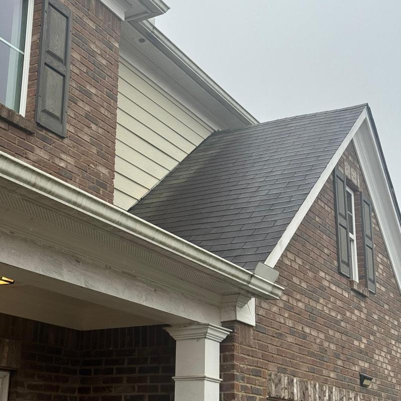 Asphalt shingle roof with wind-damaged loose shingles