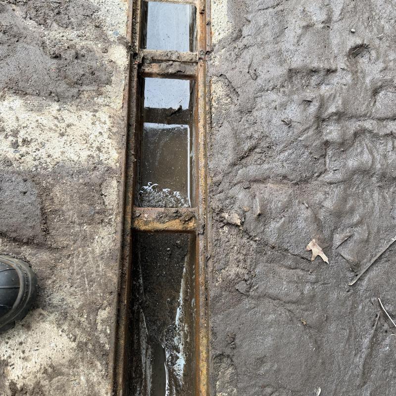 Loading dock drain with standing water and debris Loading dock drain with standing water and debris