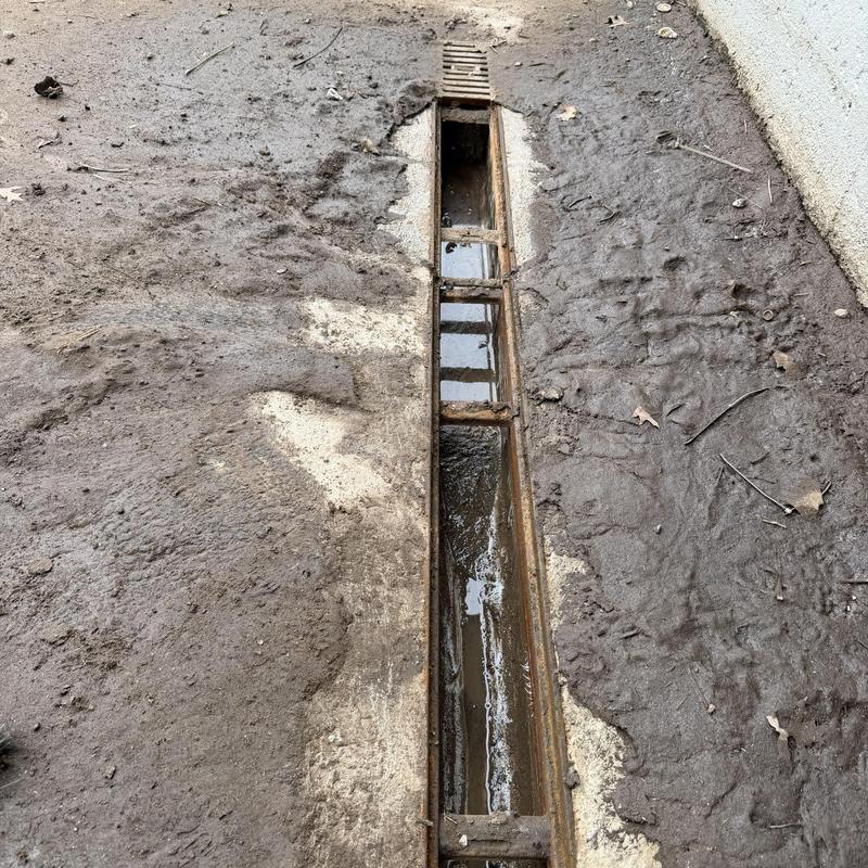 Loading dock drain with partial water and debris buildup Loading dock drain with partial water and debris buildup