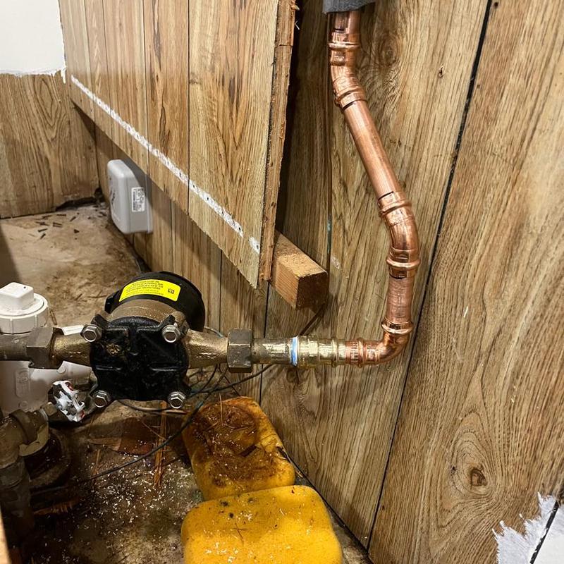 Copper water pipe with fittings inside wall paneling