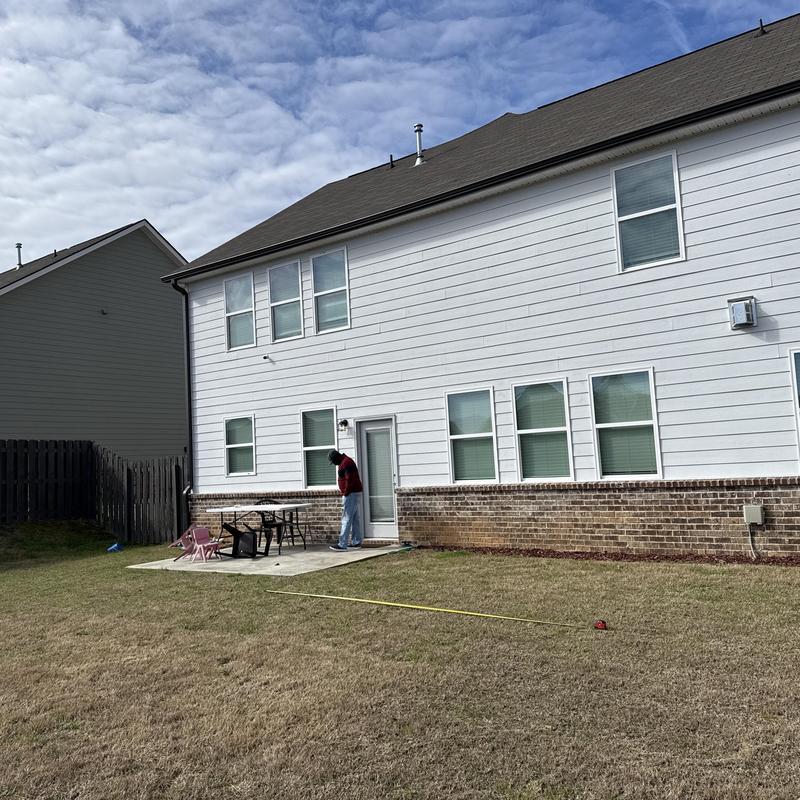 Covered patio area with concrete grilling pad and measuring tape