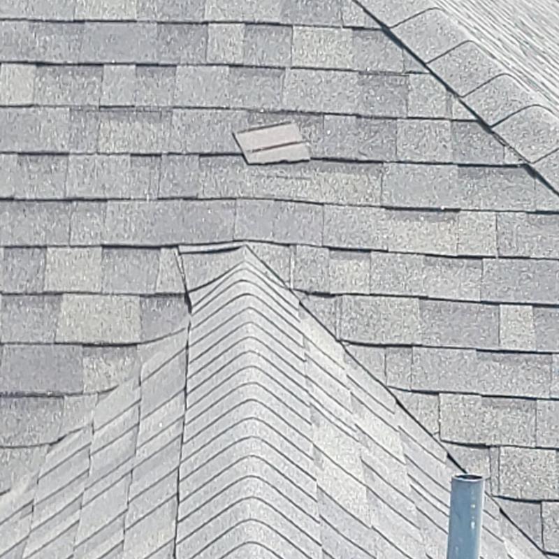 Asphalt shingle roof with missing and damaged shingles