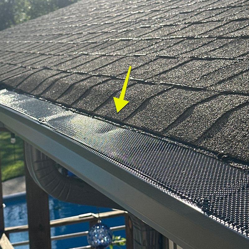 Roof shingles with hail damage near gutter guard