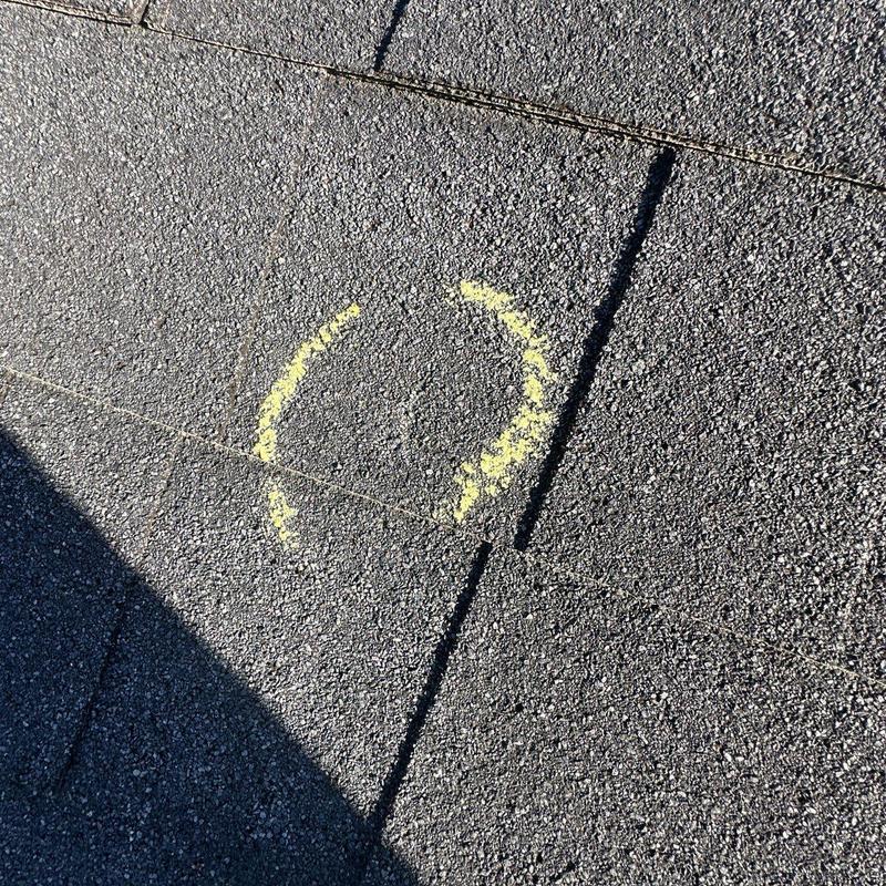 Roof shingles with hail damage marked in yellow
