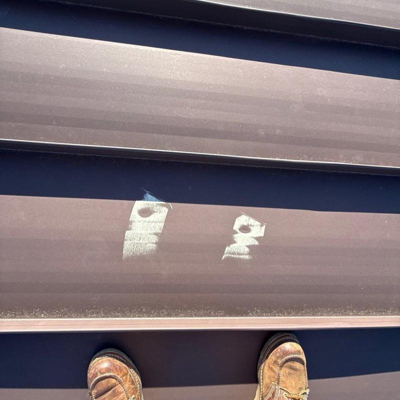 Metal roof panels with hail impact damage marks