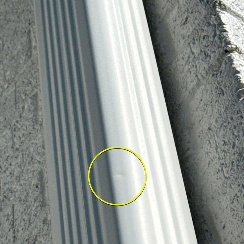 Aluminum gutter with hail dent damage highlighted