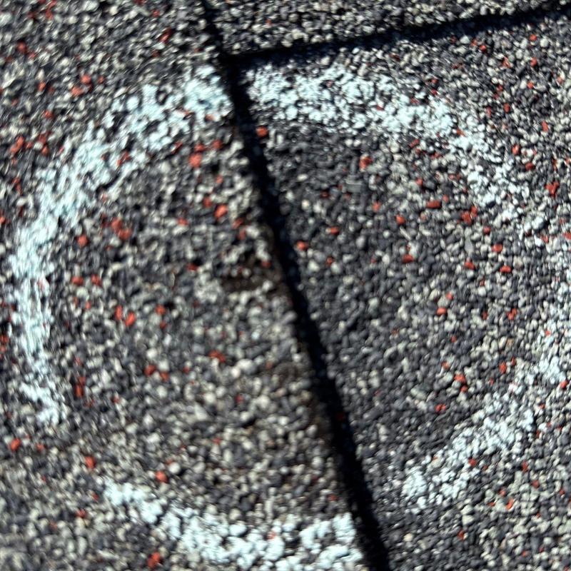 Asphalt shingle with marked hail damage close-up
