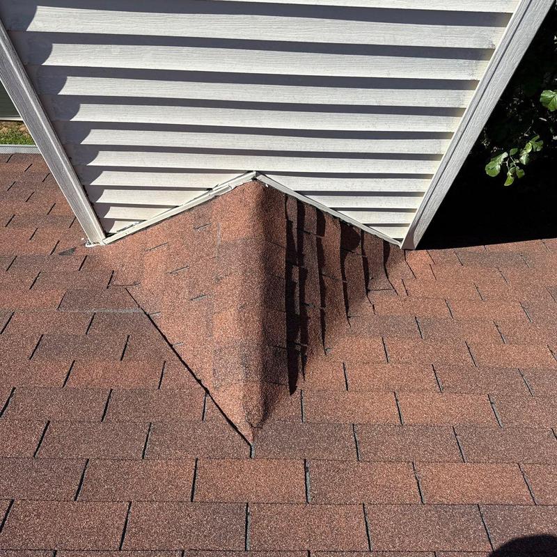 Roof shingles with hail damage near siding junction