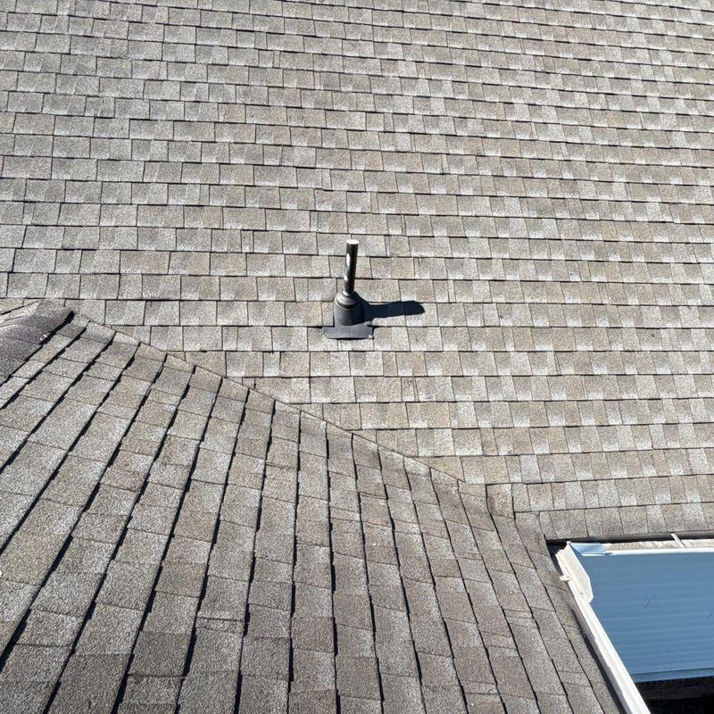 Asphalt shingle roof with plumbing vent pipe and skylight
