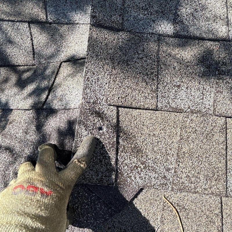 Roof shingles with hail damage and inspection glove