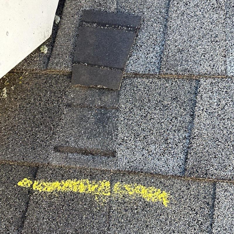 Roof shingles with hail damage and yellow marking