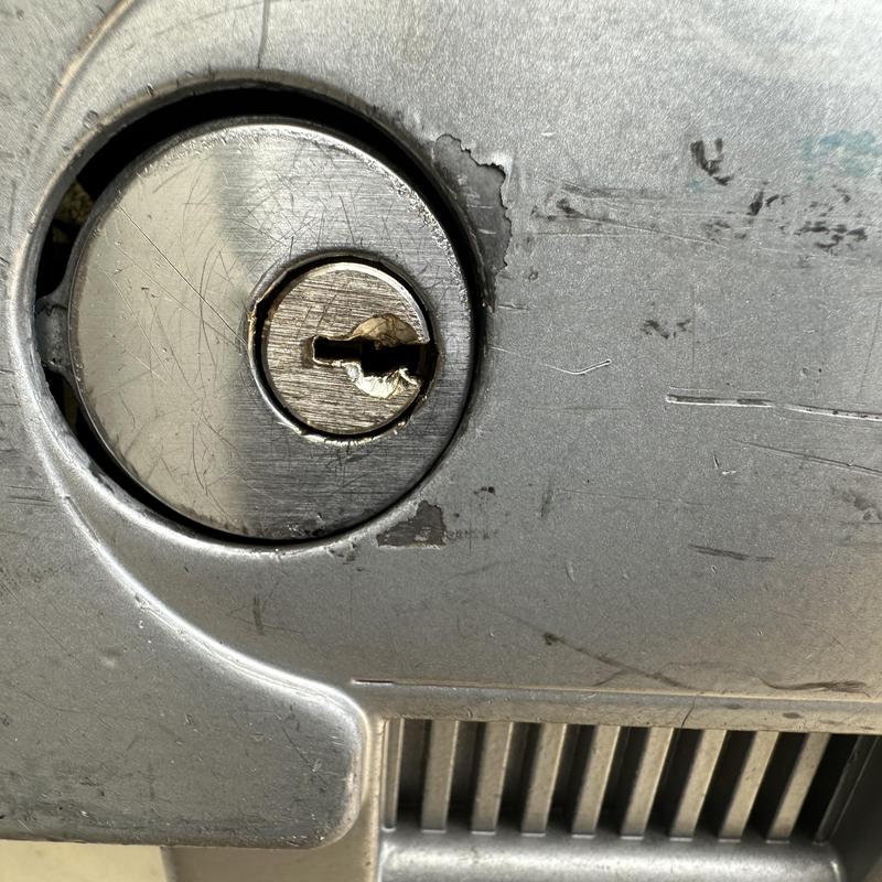 Cylinder lock with damaged key inside on metal door