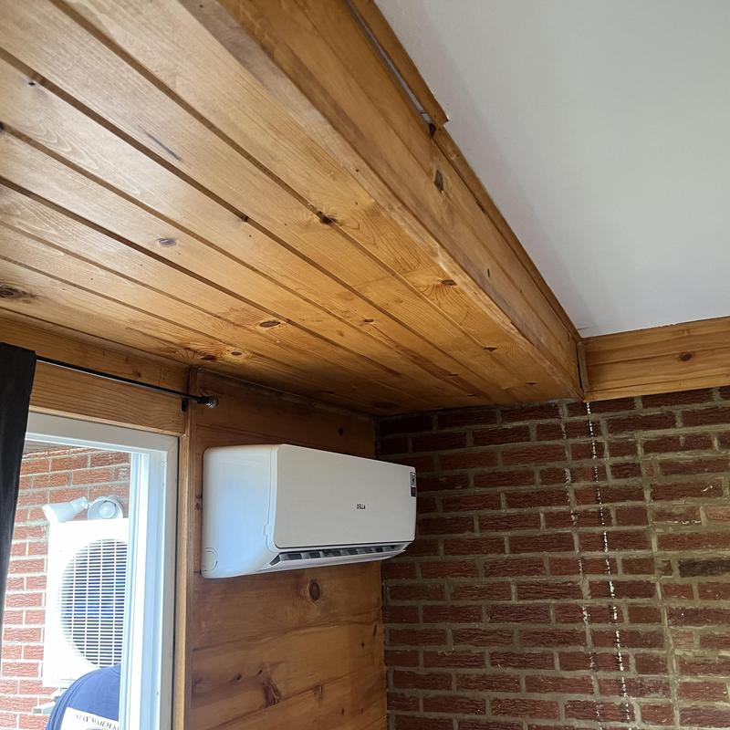 Ductless mini-split air conditioner mounted on wood wall