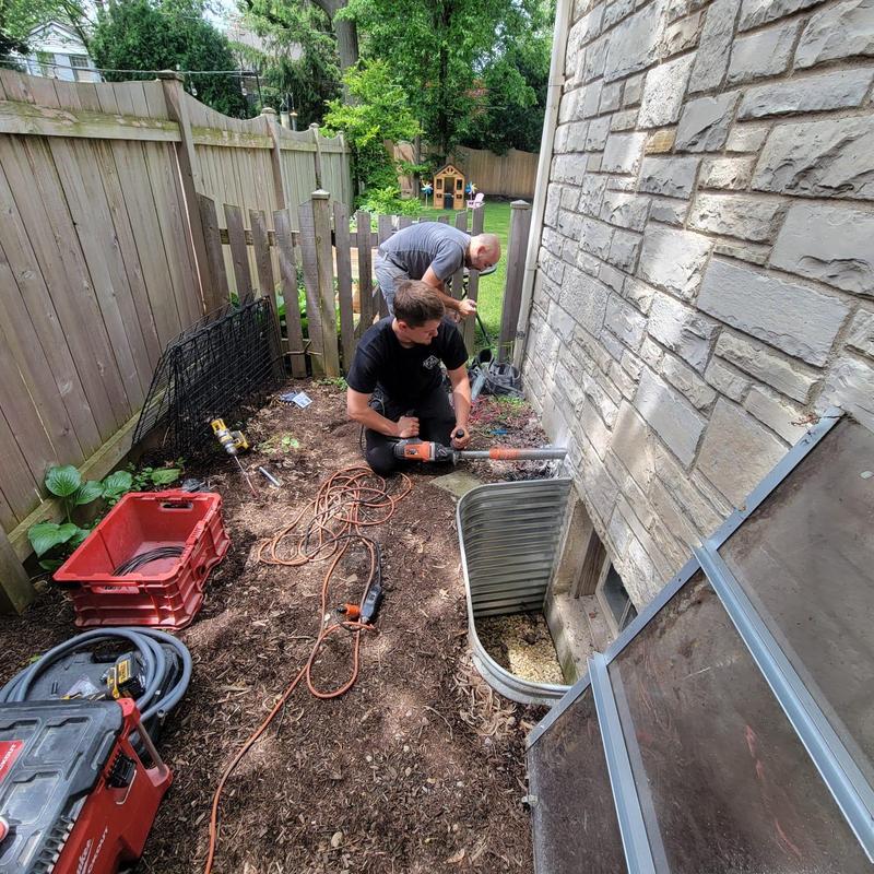Outdoor AC condenser installation by foundation wall
